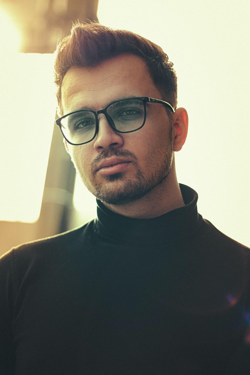 man in black crew neck shirt wearing black framed eyeglasses